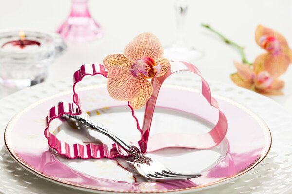 Two pink hearts with an orchid on a plate