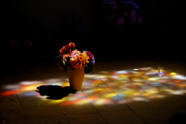 Florero con flores en el Suelo. Ramo brillante. Mala iluminación