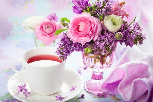 Bouquet of lilac in a vase and tea