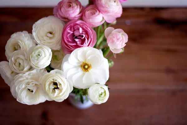 Bouquet di ranuncoli bianchi e rosa in vaso sul tavolo