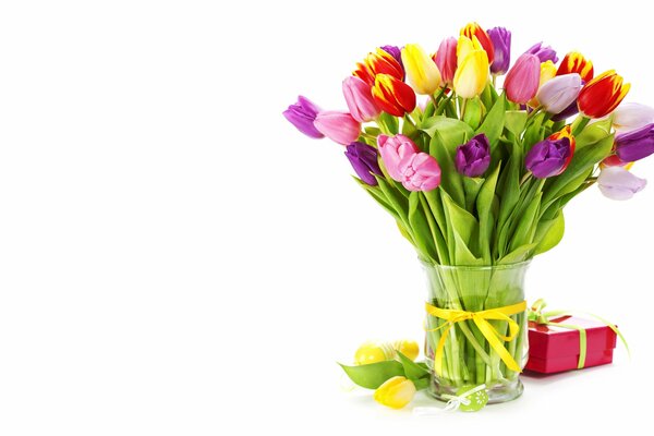 A bouquet of tulips in a vase and a gift box