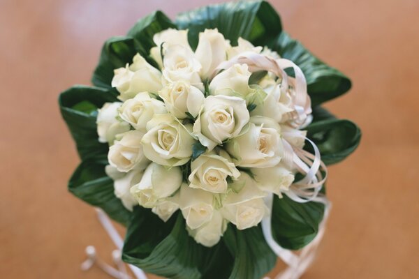 Delicado ramo de novia con rosas sobre fondo beige