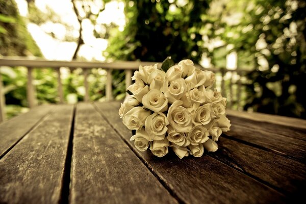 Bouquet de mariée de roses blanches sur le banc