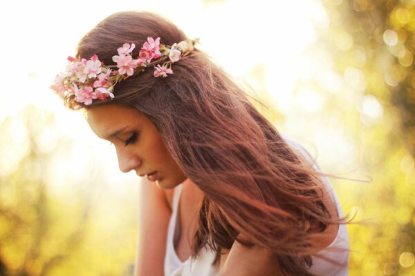 Girl with a flower wreath summer day