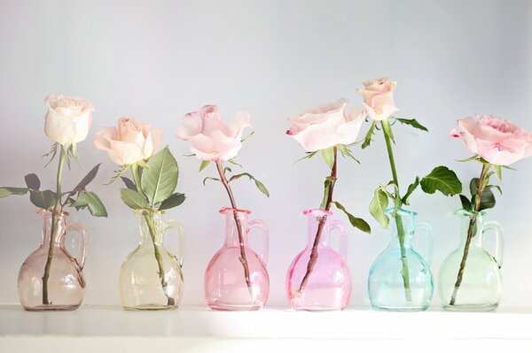 Composizione di rose in vasi di vetro