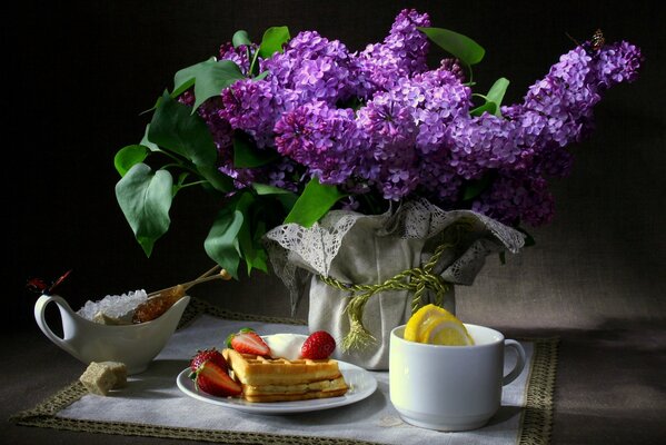 Stillleben Frühstück und Flieder in einer Vase