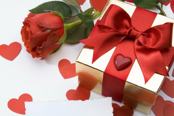 Gift box tied with a scarlet ribbon and a rose