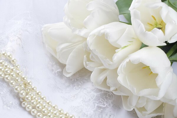 Tulipes blanches et perles sur la dentelle