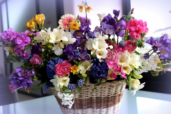 A basket with a lush bouquet of different flowers