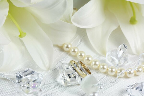 Białe lilie, pierścionki i perły