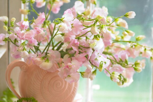 Bouquet rose dans un vase près de la fenêtre