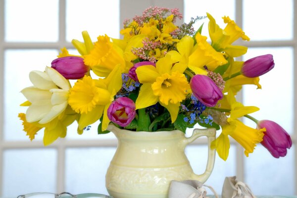A yellow bouquet in a yellowish jug