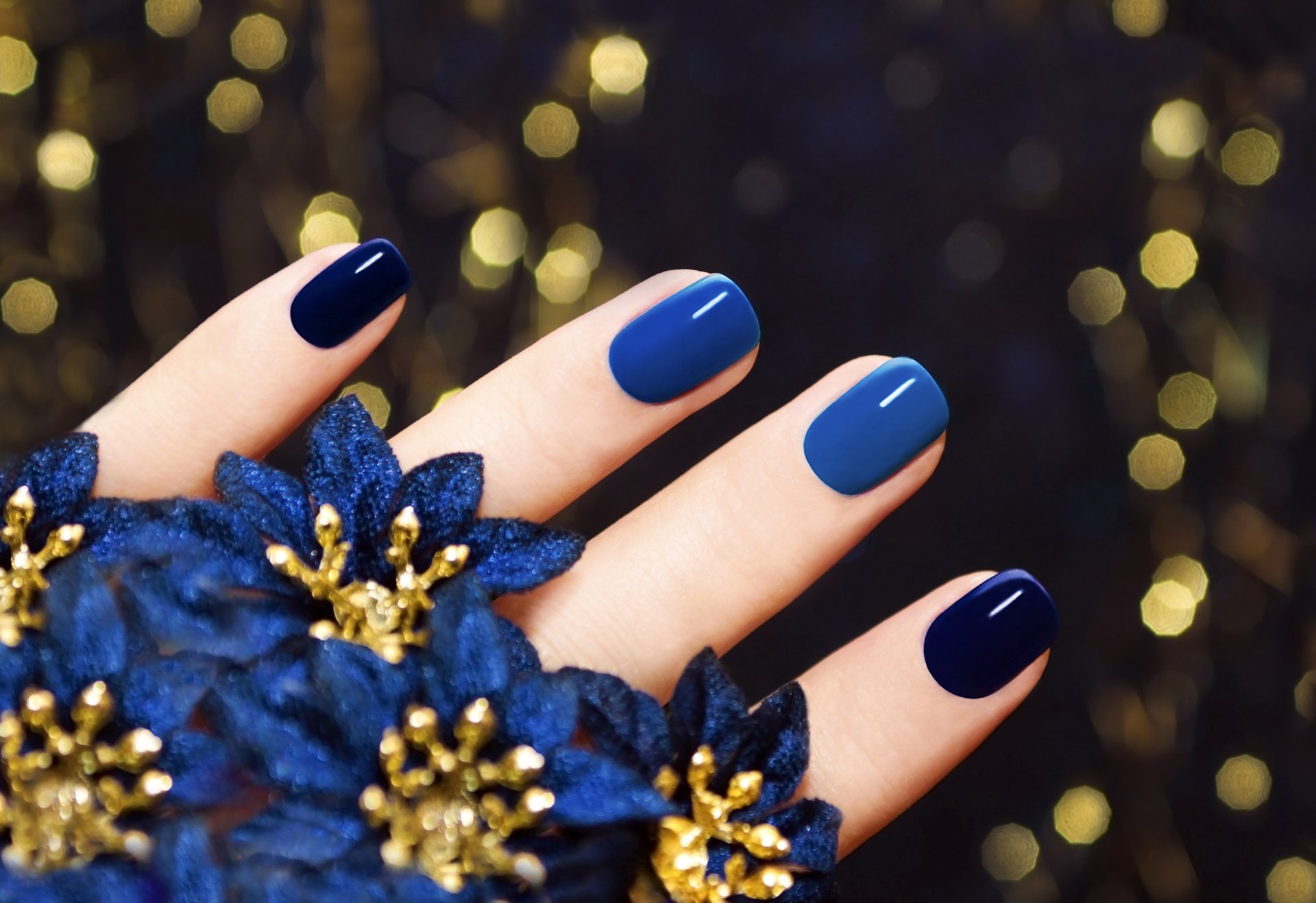 close up fingers nails manicure flowers blue background