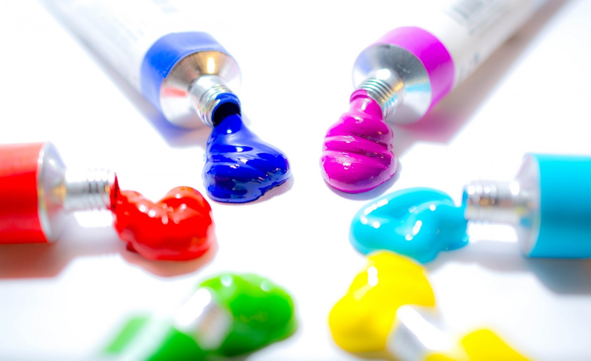 paints tubes colors blue pink light blue yellow green red light background macro