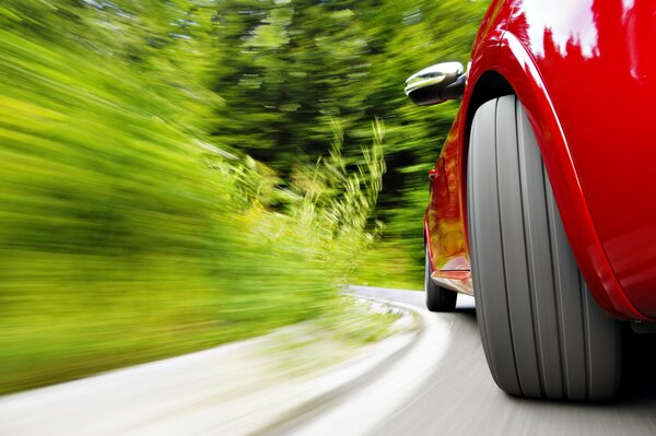 Rotes Auto mit Geschwindigkeit in einer Kurve