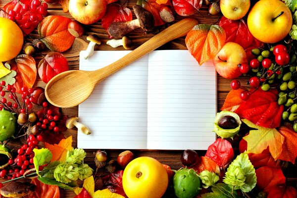 Cuaderno y cuchara de madera en la mesa con regalos de otoño