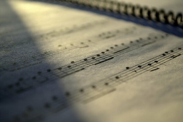 A slightly falling light on a music notebook in pitch darkness