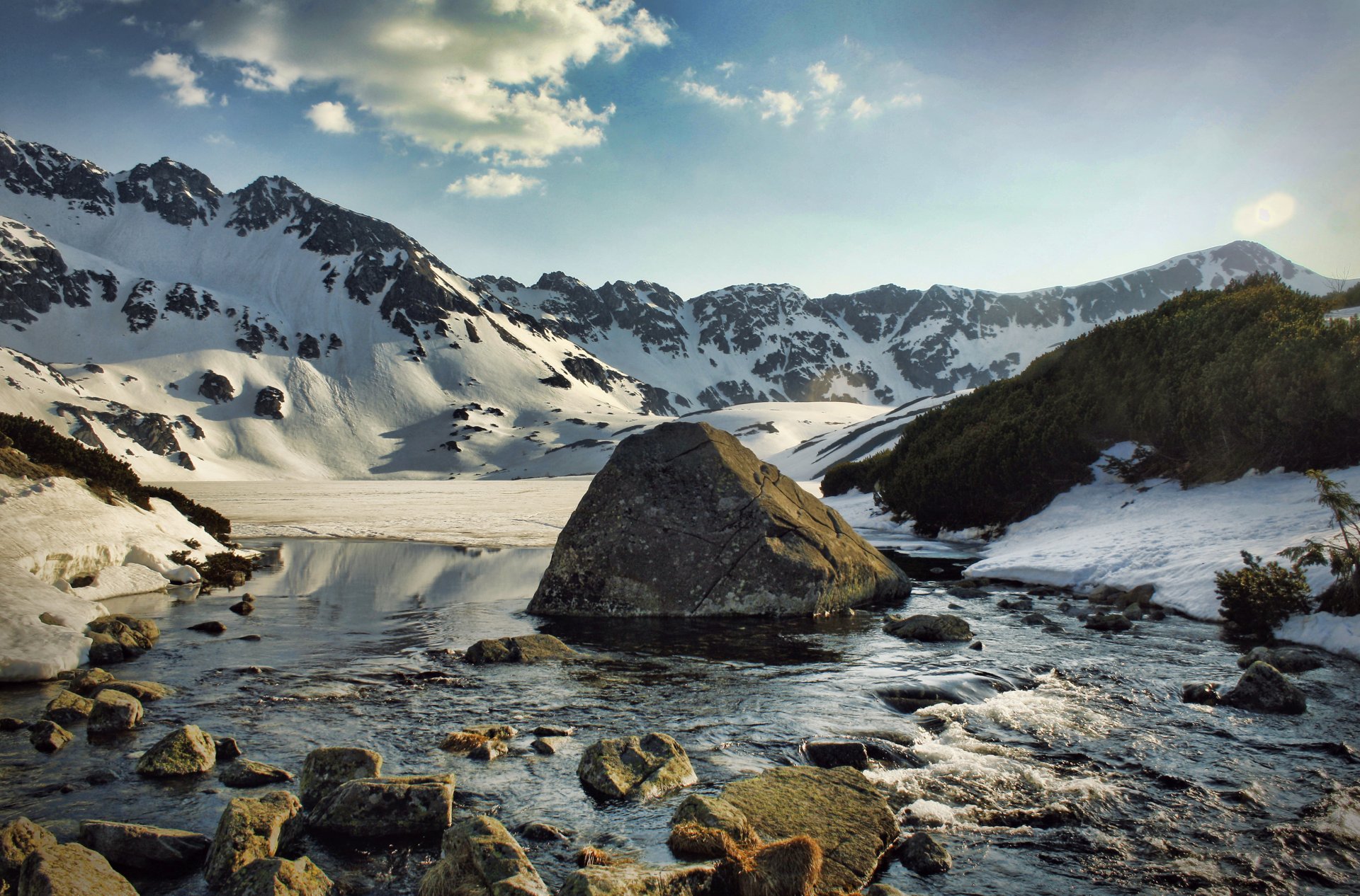 berge schnee fluss wasser stein steine kälte büsche nadeln wolken