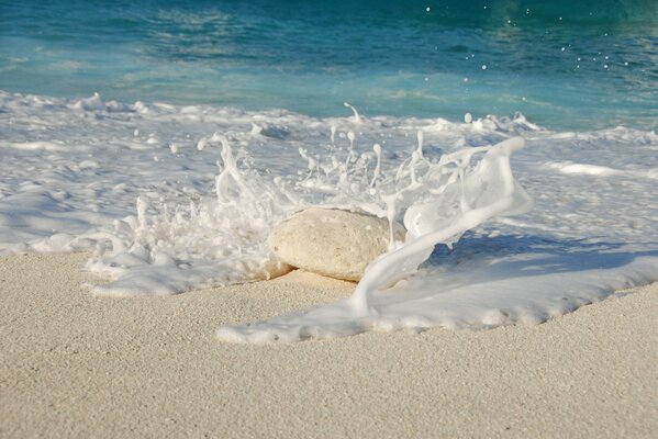 Ein Stein am Strand, der vom Ozean gewaschen wird