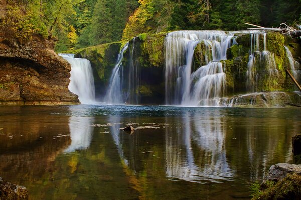 Paesaggio di una cascata che sfocia in un lago nella foresta