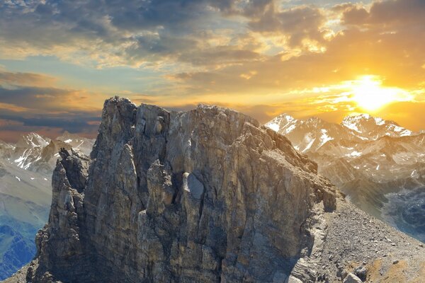 Bright sun, clouds and snow-capped mountains