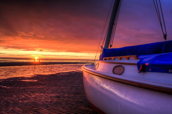 Beautiful sunset by the sea and a white yacht