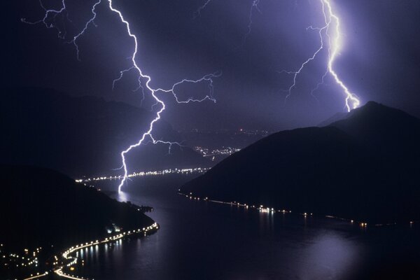 Lightning over the river and hills at night