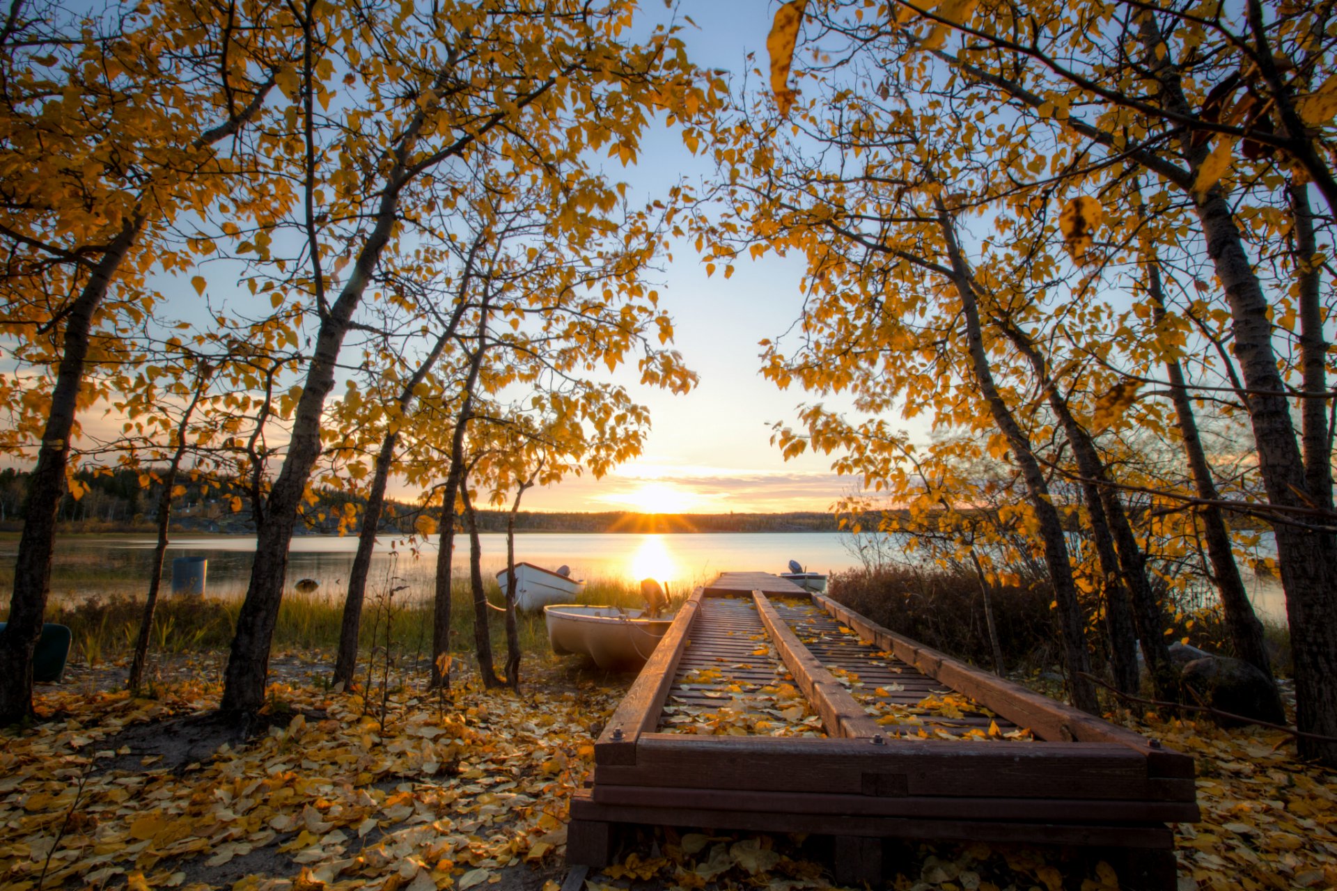 kanada herbst bäume gelb blätter see ufer boote abend sonne strahlen sonnenuntergang blau himmel wolken