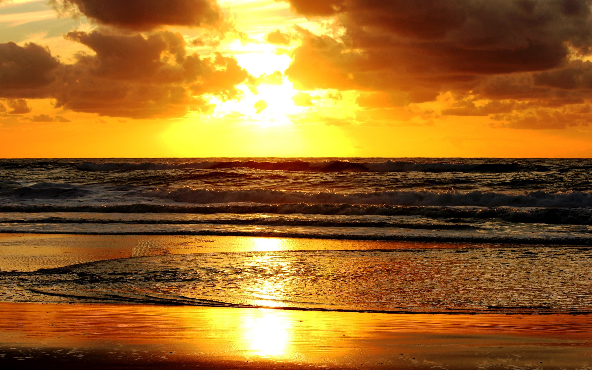 unset sea beach sand water waves clouds sun