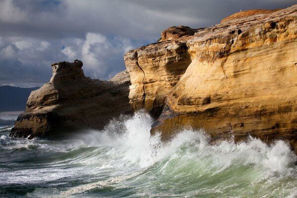 Foamy sea waves beating against the cliff rocks