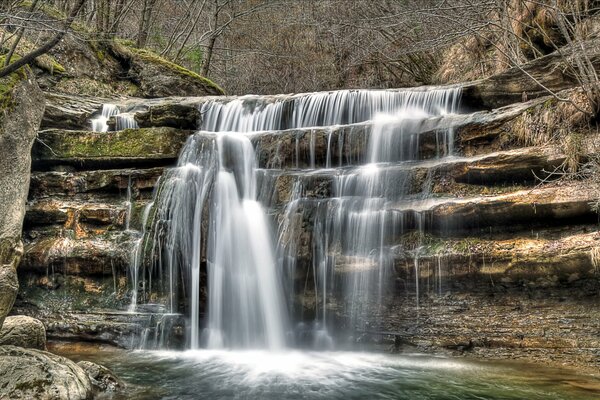 Kleiner kaskadierender Wasserfall im Wald