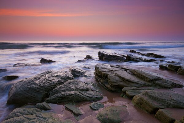 Evening sky with rocks and waves