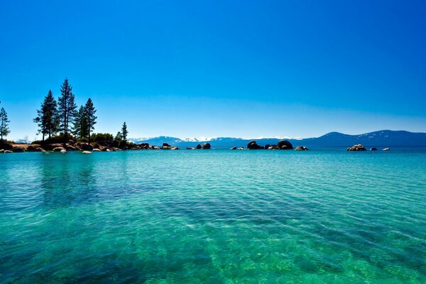 Blue transparent lake on the background of mountains and trees