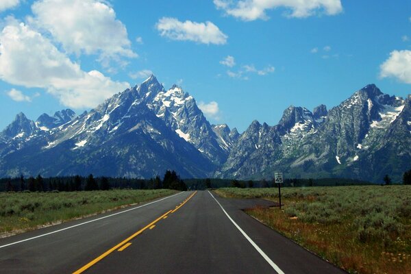 The road to the mountains with snowy peaks