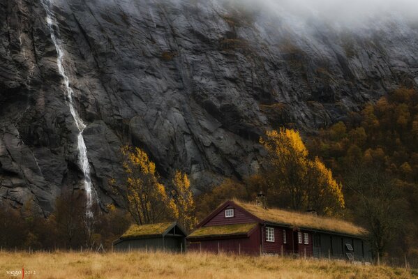 Norwegisches Haus und Wasserfall in der Nähe