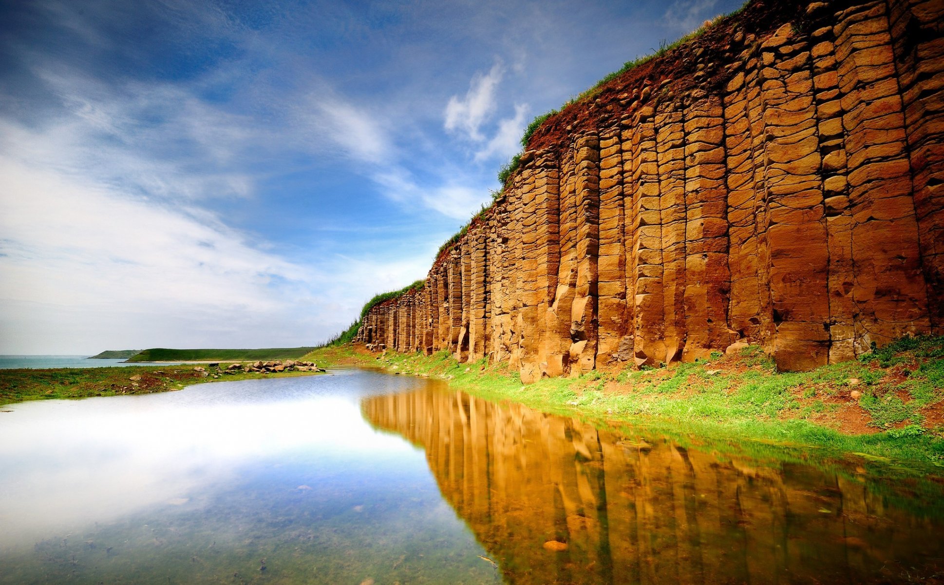 agua lago pared colina mar reflexión superficie vegetación hierba