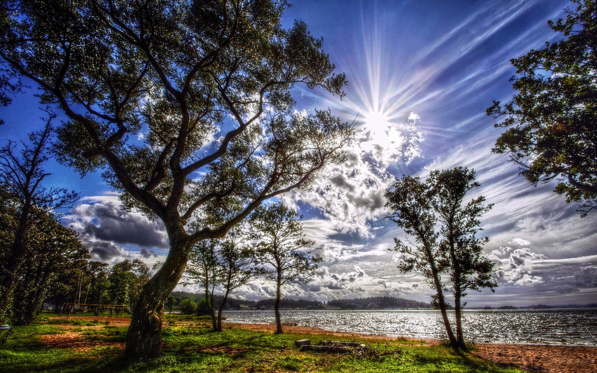 ufer gras see wald bäume hügel horizont ferne himmel wolken sonne licht strahlen