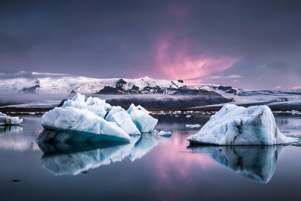 Snow-white mountain peaks. Ice blocks in the foreground