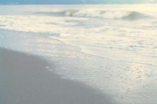 Ruhige Wellen waschen den Strand