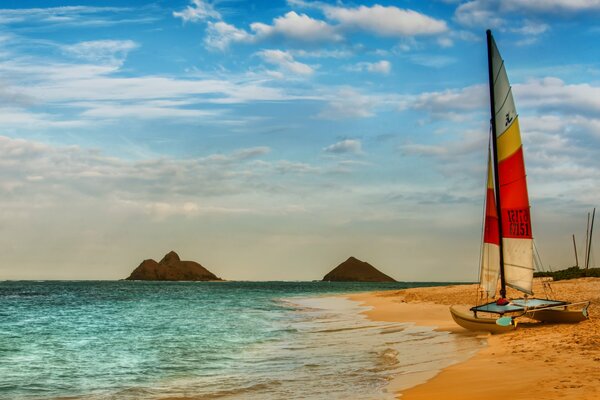 Catamarán de vela en la playa junto al mar