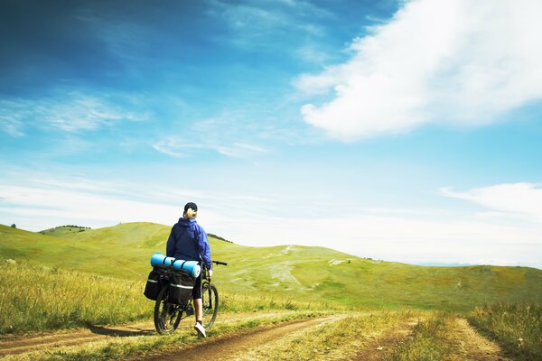 A girl travels by bike among the hills