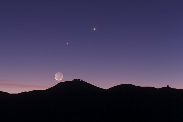 Cielo estrellado. Imagen oscura de las montañas. Planeta en el cielo