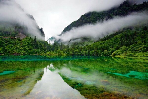 Surface miroir du lac, reflétant les collines verdoyantes