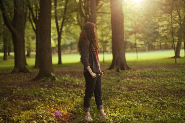 A girl in nature among trees and grass