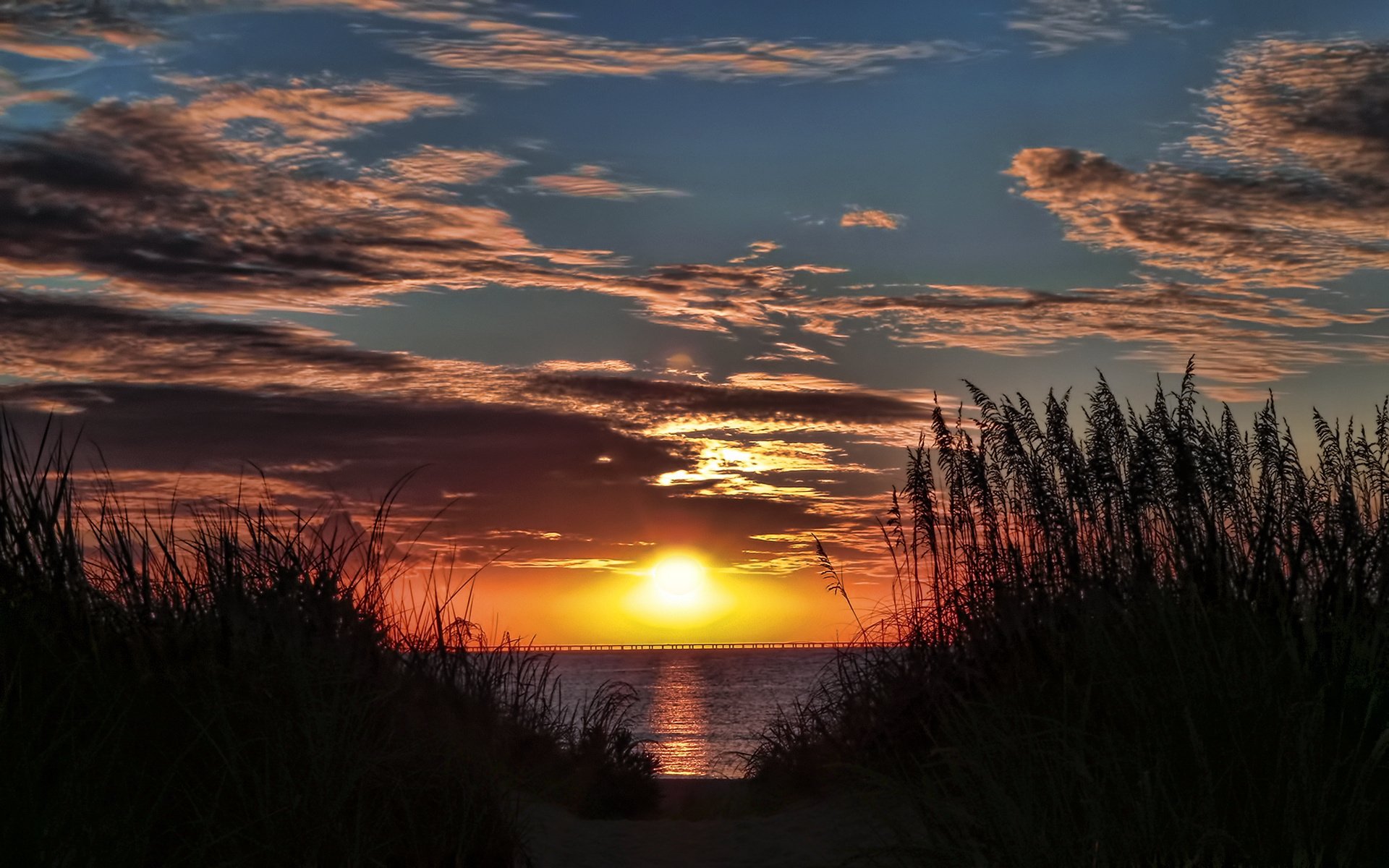 sera cielo nuvole sole arancione tramonto fiume ponte lontano