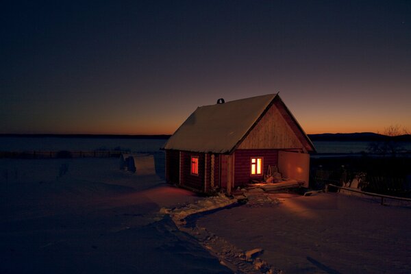 Maison avec des fenêtres lumineuses dans la steppe