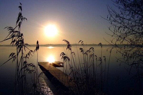 Zachód słońca na bezchmurnym niebie nad jeziorem