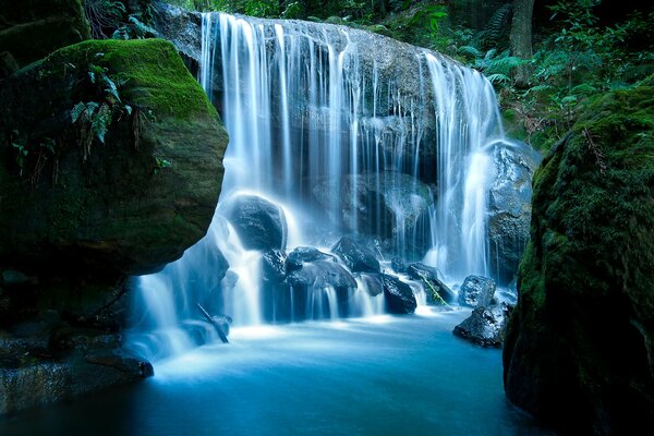 The most beautiful waterfall flows into the blue lake