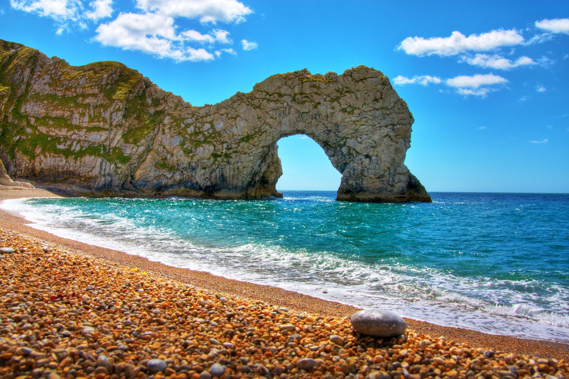 nature mer rocher arche plage cailloux ciel nuages jour clair