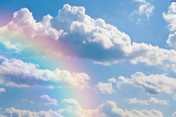 Colorful rainbow among white clouds